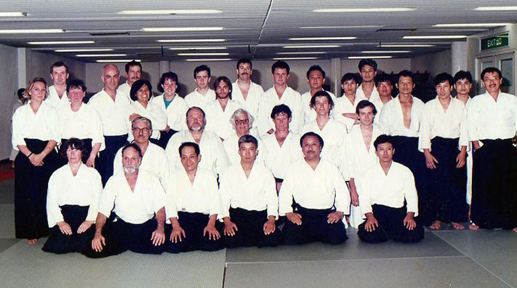 1991年、香港合気道協会設立20周年記念 （当時の道場長・植芝守央氏出席）。前列左2番目 から：ケン・コティエ、ポール・リー、植芝守央、 藤田昌武、金澤威