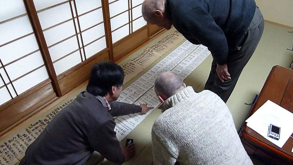 オリビエに巻物の説明をする千葉先生と佐藤先生。